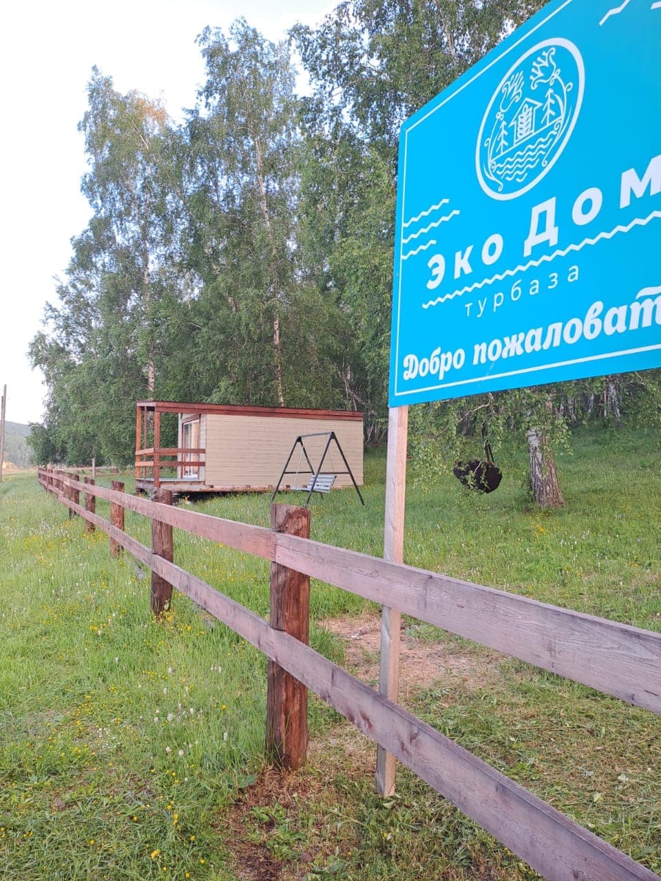 Экодом Покровка: вывеска турбазы и домик за ограждением